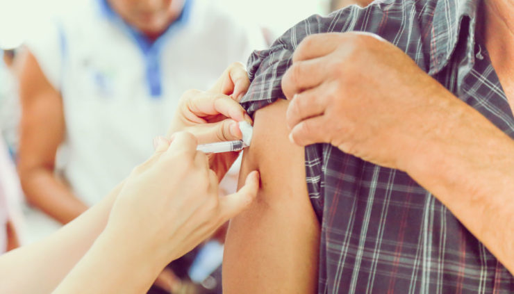 person getting a flu shot in the arm